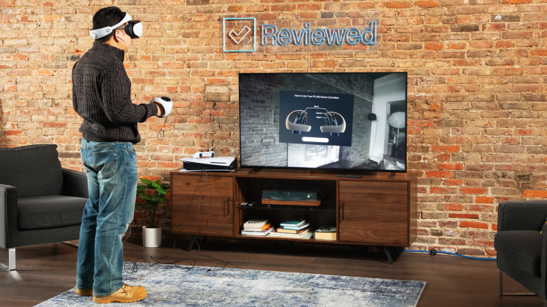 A person facing a flat screen TV, using the PSVR 2 headset.