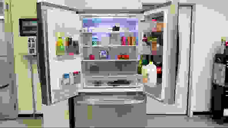 The LG LRF0C2606S Refrigerator with its doors open, showing foods and condiments inside.