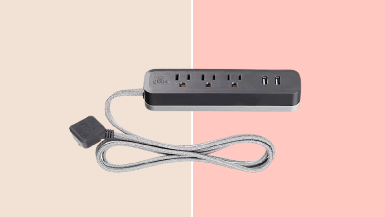 A gray power strip against a light pink background.
