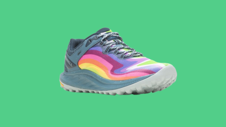 A rainbow-colored sneaker against a green background.