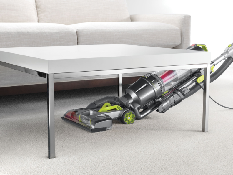A Hoover vacuum cleans under a table