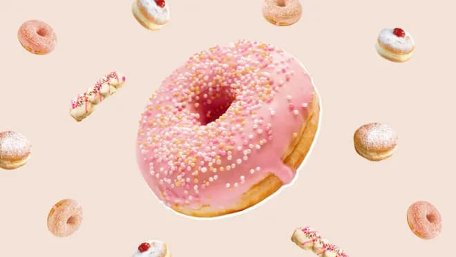 Pink frosted donut on beige background