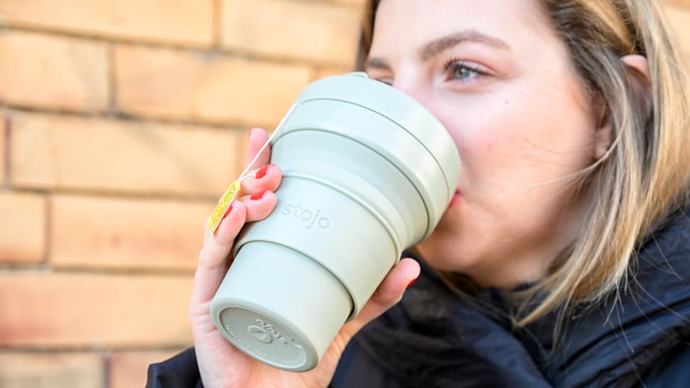 A photo of a woman drinking from the Stojo Cup.