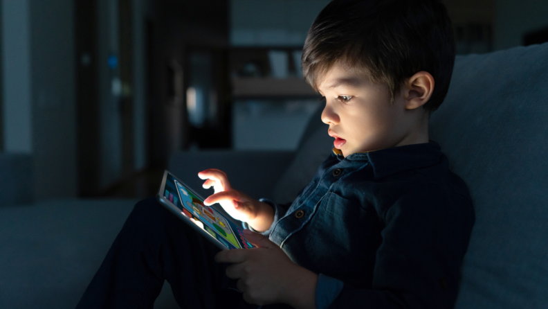 boy using tablet in the dark