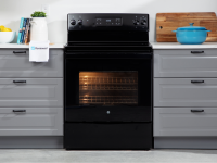 The GE JBS60DKBB electric range in black sits in a kitchen between grey cabinets.