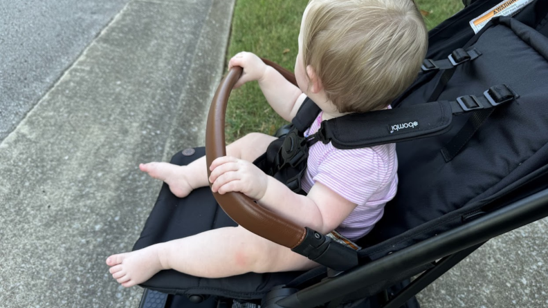 Baby grabbing handlebar of the Bombi Bebee Stroller