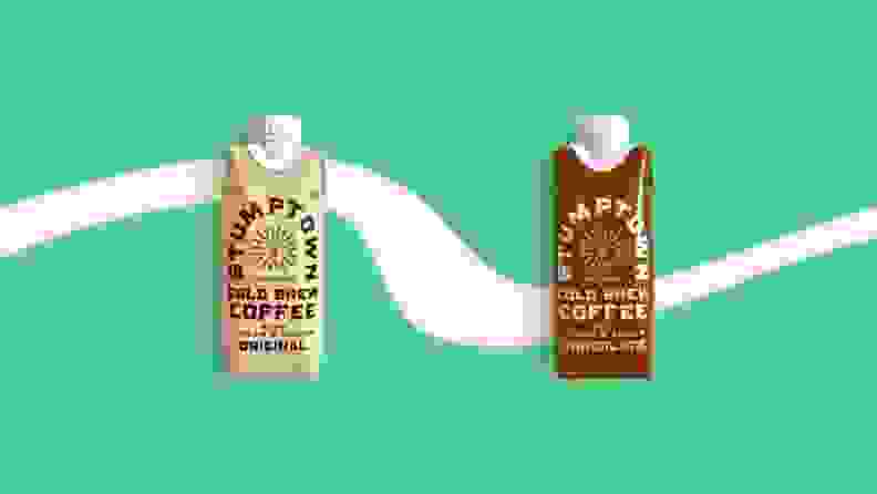 Two juice-box-style single-serve boxes of cold brew coffee on a green background.