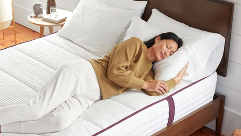 A woman laying on an Awara mattress in a bedroom setup.