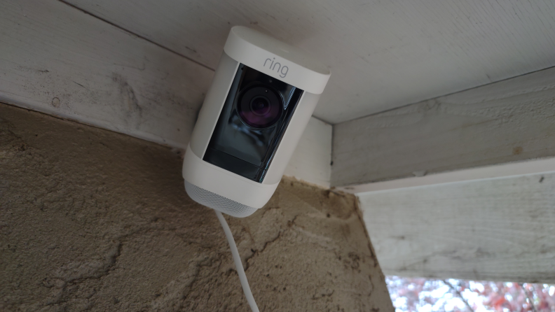 Product shot of the mounted Ring Spotlight Cam Pro security camera outside of home.