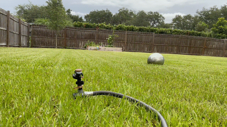 A gif of a sprinkler watering the grass