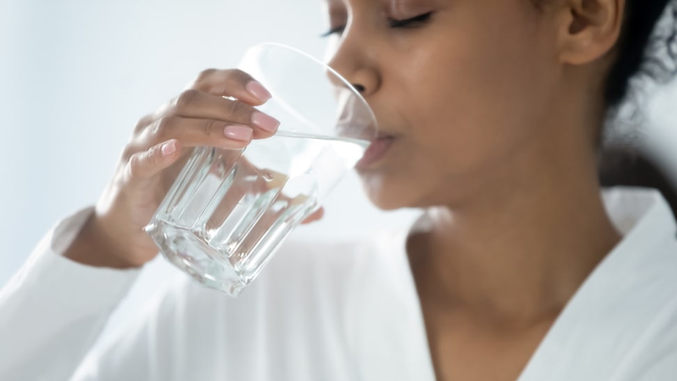 一个女人用透明的玻璃杯喝水的特写镜头