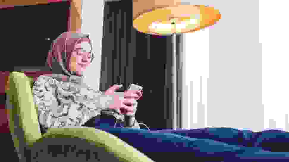 Person sitting in recliner using cell phone.