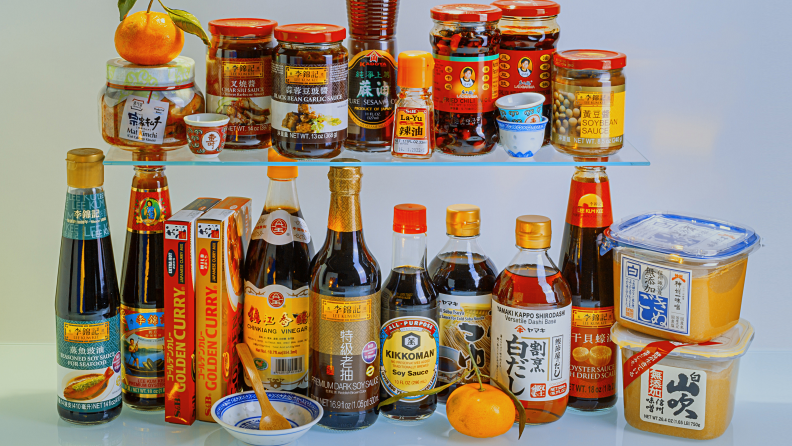 A collection of condiments for Asian cooking. From the top left: picked ginger, Chinese barbecue sauce, hoisin sauce, sesame oil, seasoning, lao gan ma chili crisp, lao gan ma broad bean paste, and fermented tofu. From the bottom left: soy sauce for steaming fish, oyster sauce, Japanese curry cubes, chingkiang black vinegar, kikoman soy sauce, shoyu, miso paste.