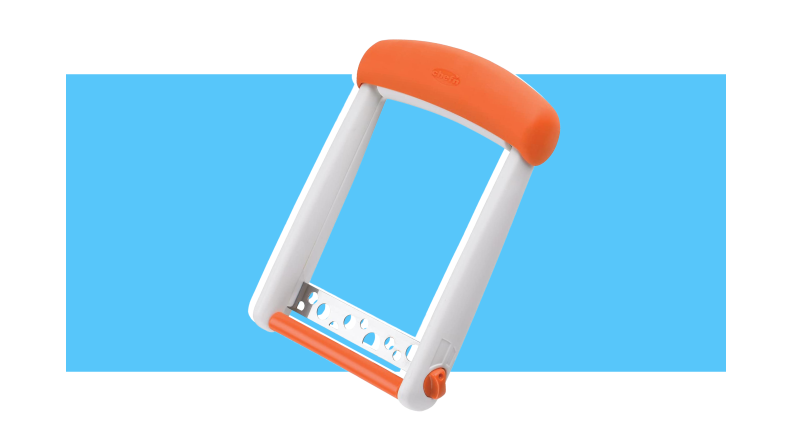 An orange and white cheese slicer against a blue background.
