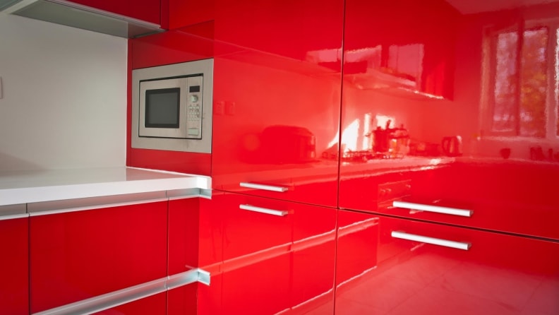 Sleek, red cabinets reflecting the rest of the kitchen.