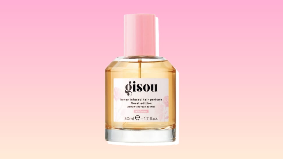 Gisou Wild Rose Hair Perfume against a pink and yellow background.