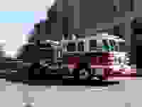 一辆快速移动的红白相间的消防车的照片。