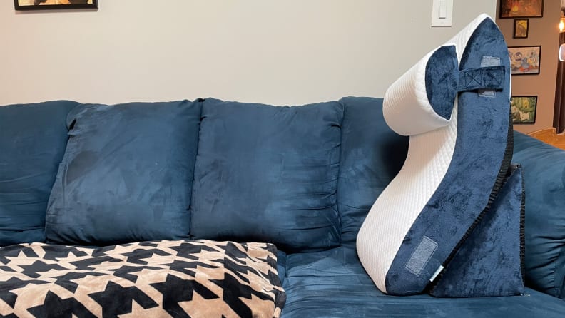 A navy and cream Qirroboni Orthopedic Indigo Bed Wedge Set on top of a blue suede couch.