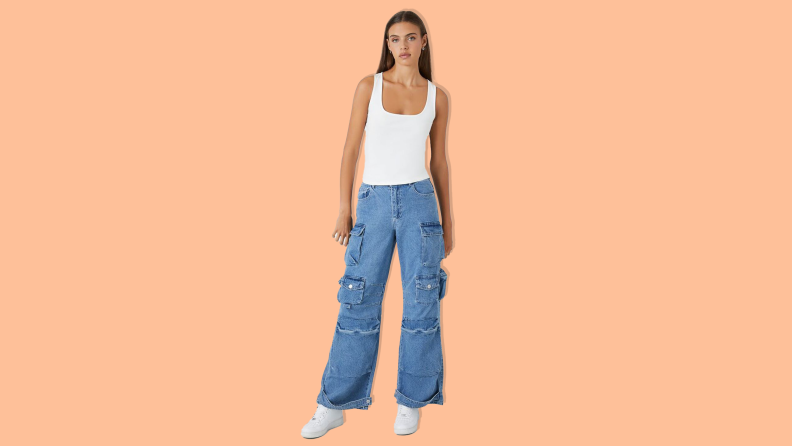 Woman wearing Forever21 straight-leg cargo jeans on orange background.
