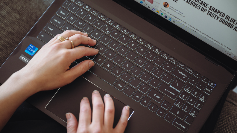 A person types on the laptop keyboard.