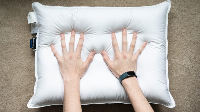 hands pressing down onto a pillow
