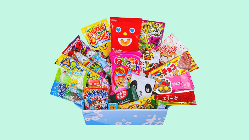 A light blue Sakura box bursts with various packages of Japanese candy.