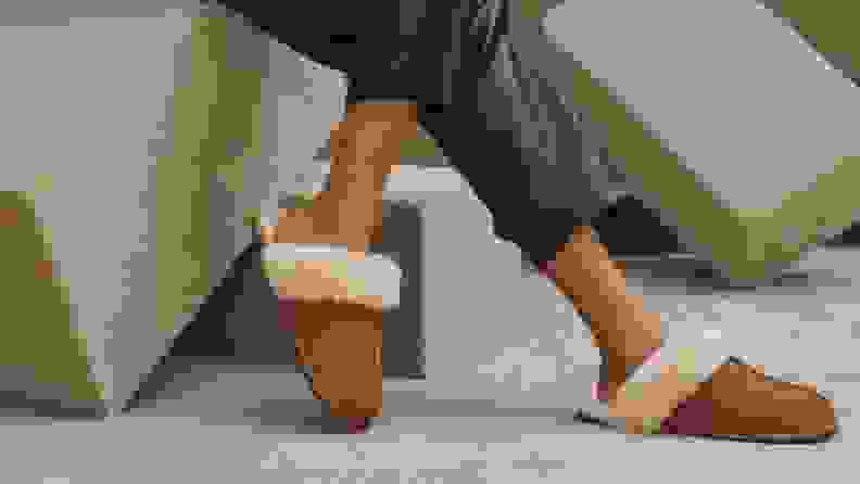 一个人穿着UGG女性的Scuffette II拖鞋