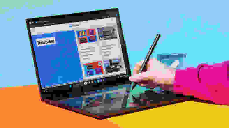 Person using a stylus pen on the bottom touchscreen of the 2024 Asus Zenbook Duo laptop.
