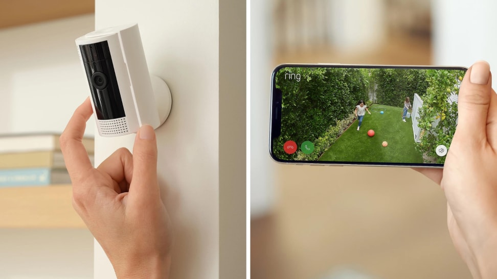A Ring security camera inside a home next to a smartphone being held by a hand indoors.