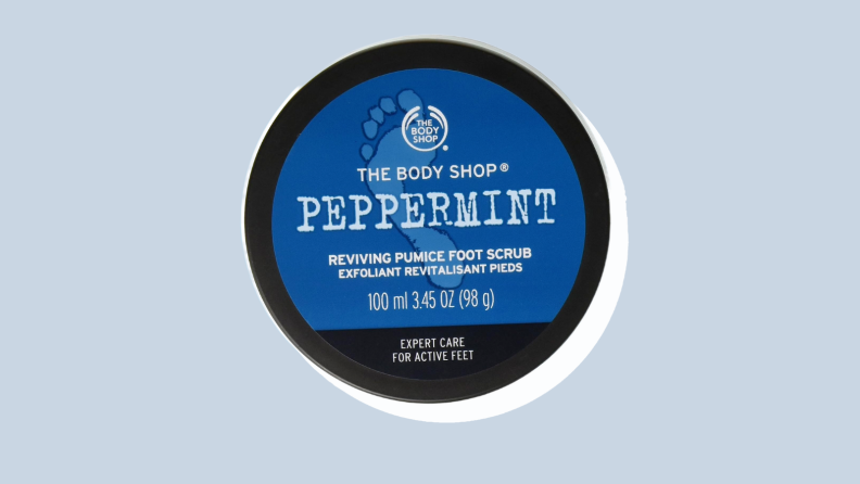 The Body Shop foot scrub in front of a light grey-blue background.