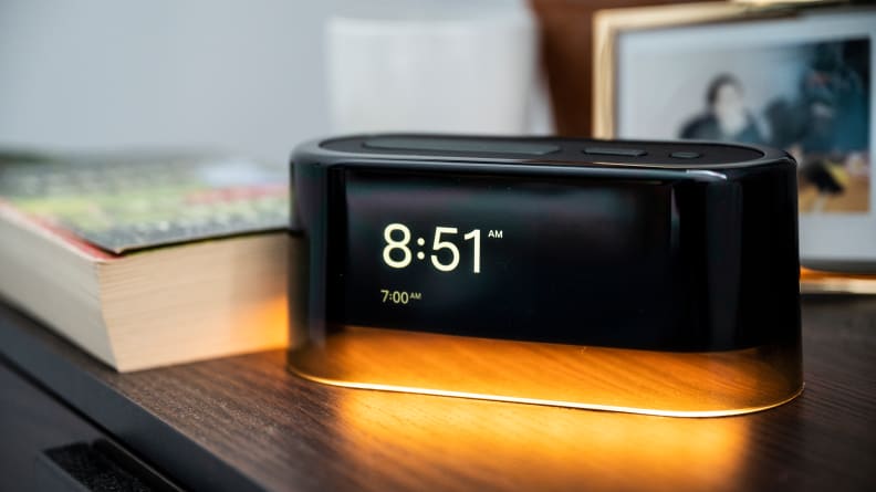 a loftie alarm lightly illuminating a side table