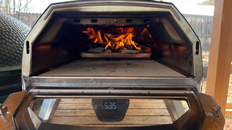 An open Ooni Karu 16 oven with fire in the back