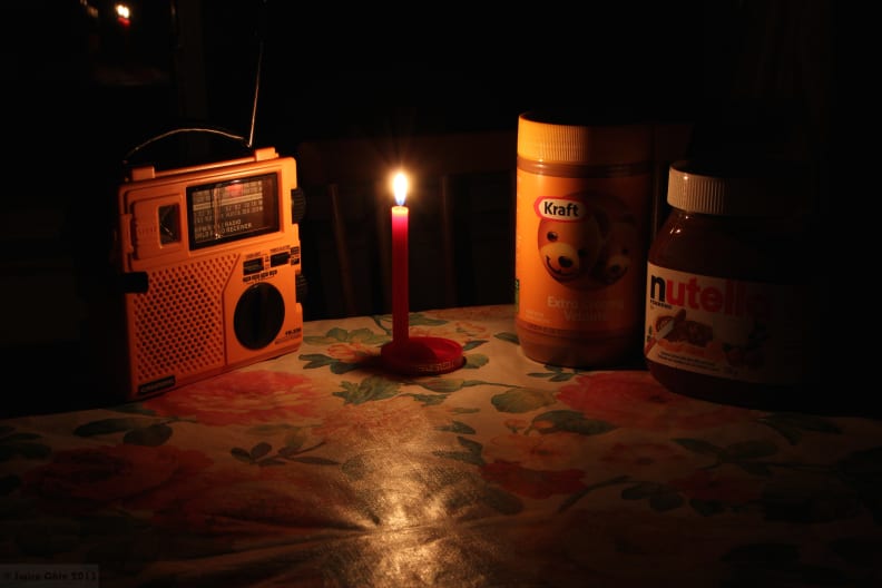 A radio and food under candlelight during a power outage