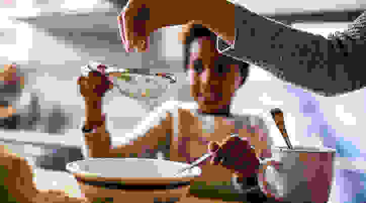 Child cooks with adult in the kitchen