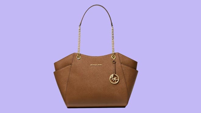 Brown leather bag against purple background
