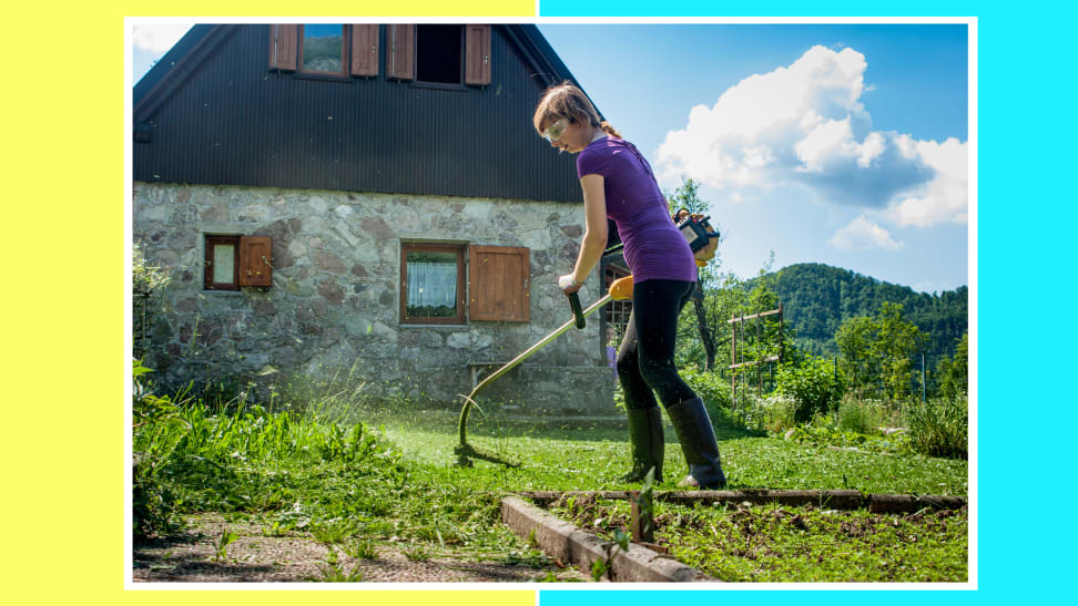 Person maintaining their lawn while holding weed wacker string grass trimmer outdoors behind home.