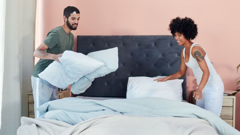 a couple makes the bed