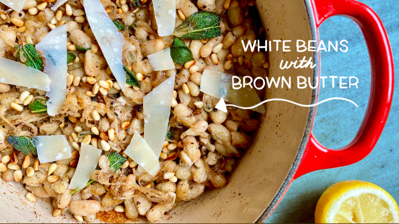 White beans and brown butter dish in a red Dutch oven.