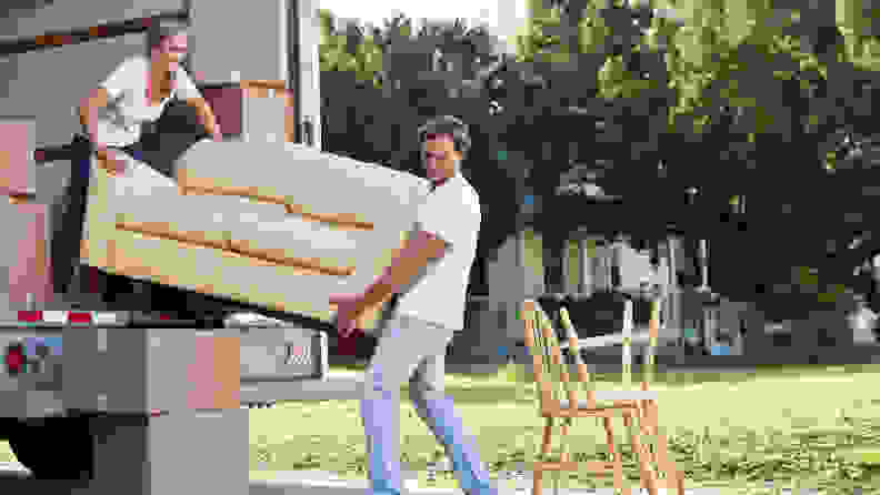 Man and woman loading couch into a truck