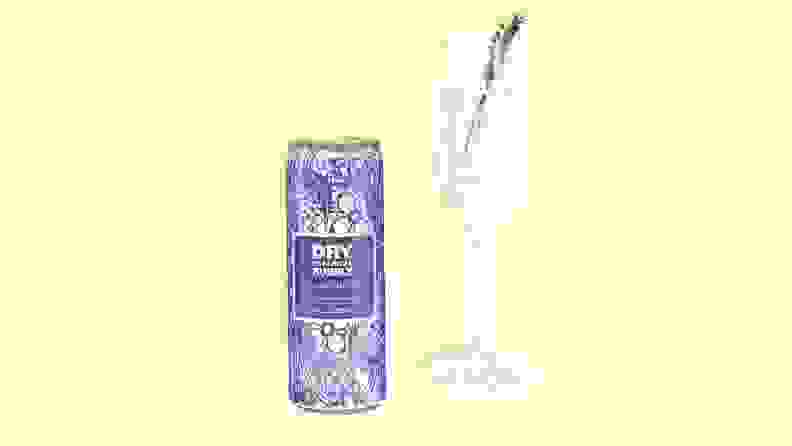 A can of Dry bubbly beside a flute garnished with lavender