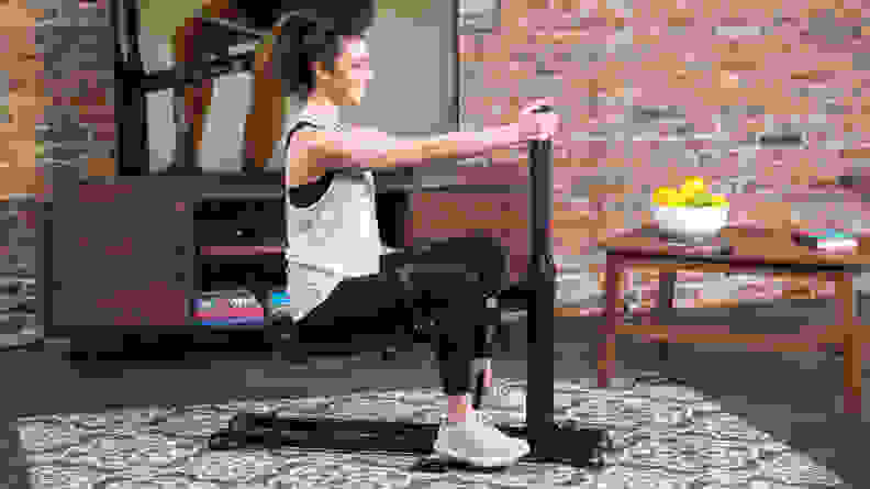 Woman in a squat position on the DB Method machine.