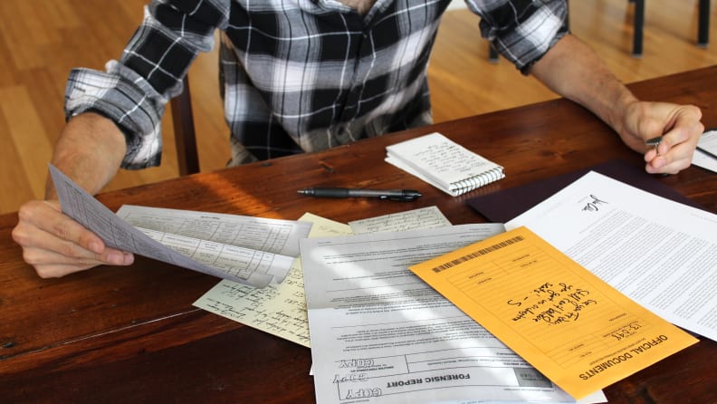 Man looking at stacks of paper on his desk