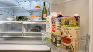 A shot of the interior of a fridge, focusing on its door bins and the lower half of its refrigerator compartment. The fridge is stocked with food.