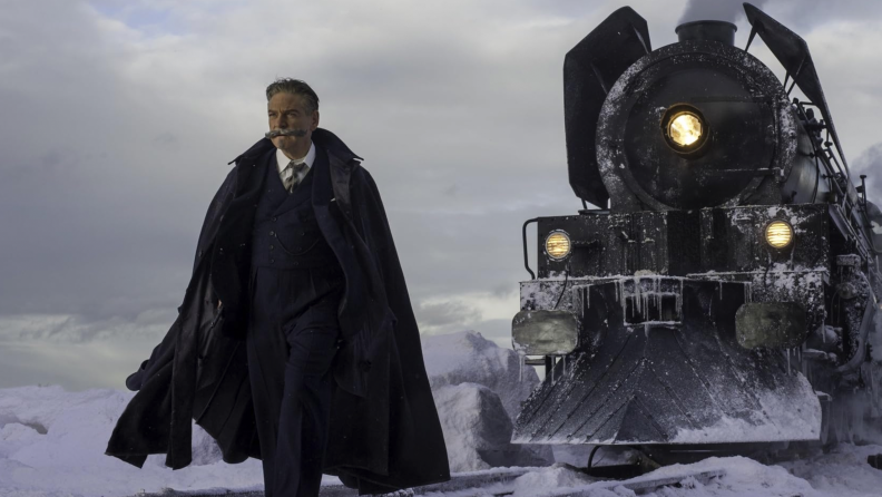 Kenneth Branagh as Hercule Poirot in front of a train in Murder on the Orient Express.