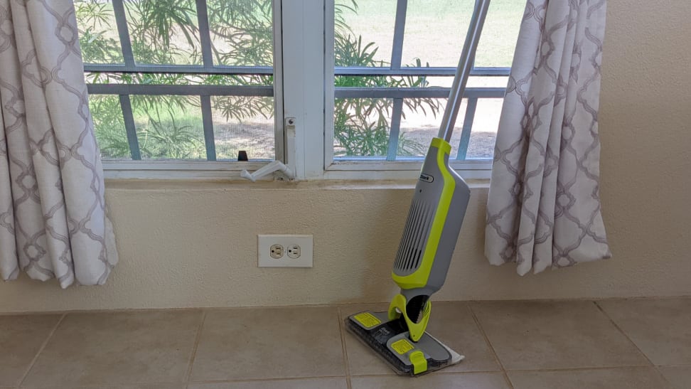 The Shark VacMop leaning against a sunny window with white curtains