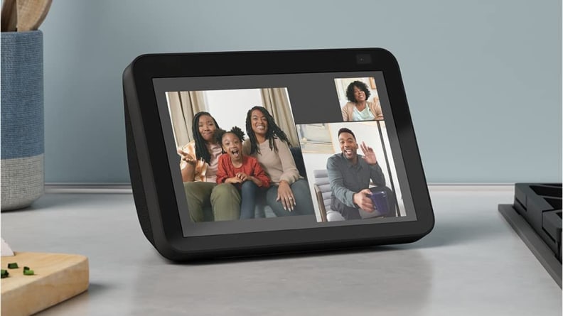 Smiling family connecting with each other via video call on smart tablet sitting on counter.