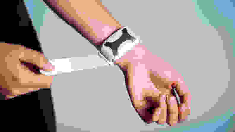 A person adjusts the Apollo Neuro strap on their wrist.