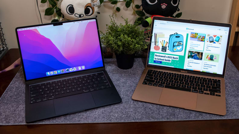 The two MacBook are open, side by side on the table.