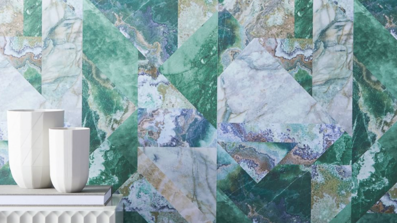 Green, blue and gray faux marble wallpaper with white vases on the bottom left corner of the frame.