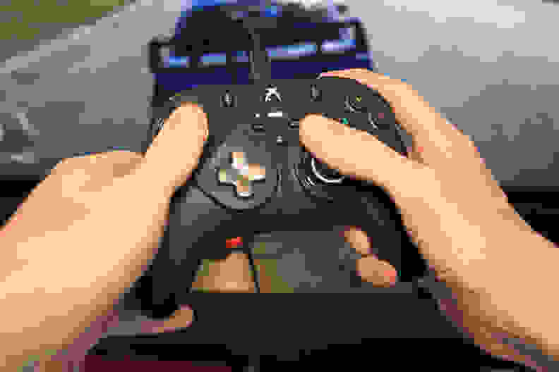 A pair of hands holding the controller to play video games.